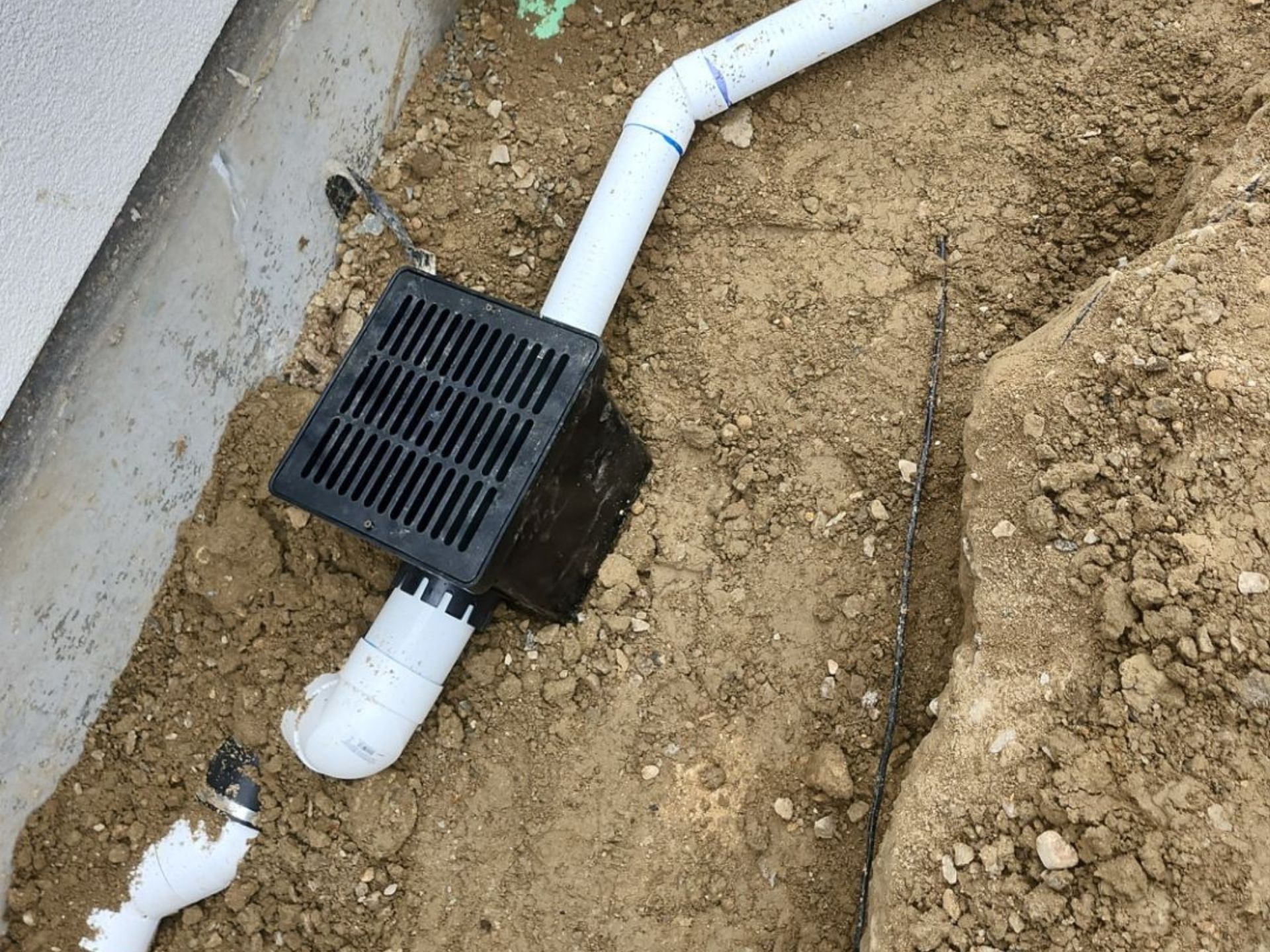 Drainage pipe and grate installed beside a home